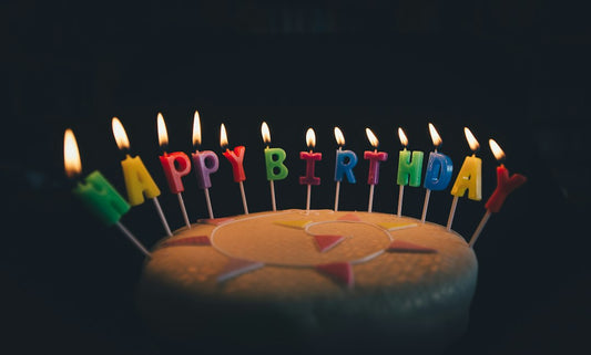 A round birthday cake with lit candles — Birthday Card Bible Verses from Nordenzi