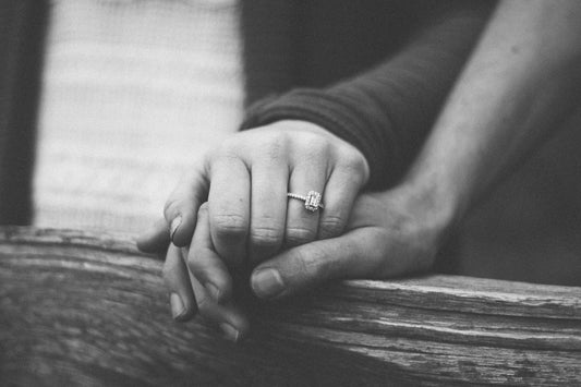 Engaged couple holding hands with a wedding ring visible — Christian Engagement Gifts from Nordenzi