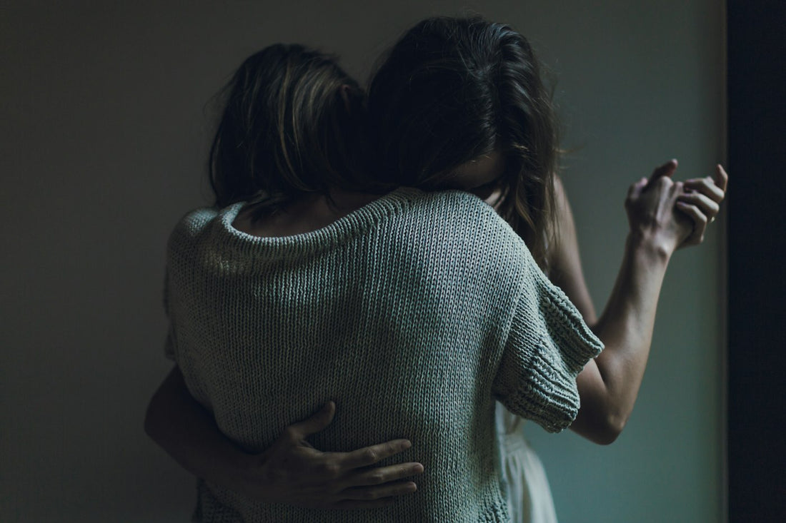 Two sisters embracing in a comforting hug — Nordenzi reflection on coping with the loss of a parent