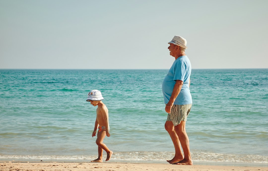 A grandfather and grandson standing together on the seashore — Christian Gifts for Grandpa from Nordenzi