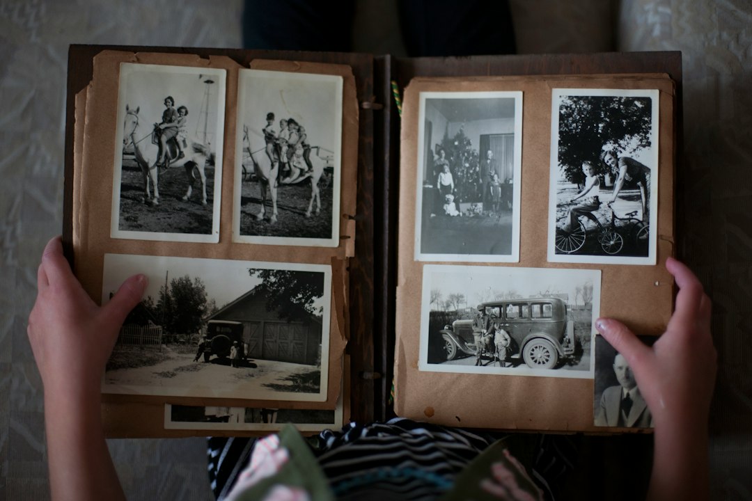A family quietly looking through an old photo album together, remembering a loved one at home — Nordenzi Christian memorial gifts guide