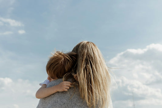 A bonus parent holding a child close against a cloudy sky — Stepfamily Day Messages from Nordenzi