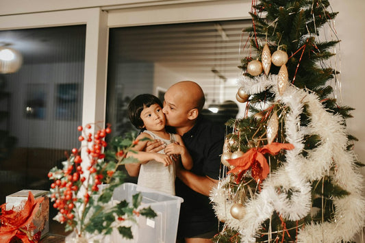 A father and his young daughter standing together by the Christmas tree, a quiet family moment during the holidays – Nordenzi Christmas Gifts for Dad