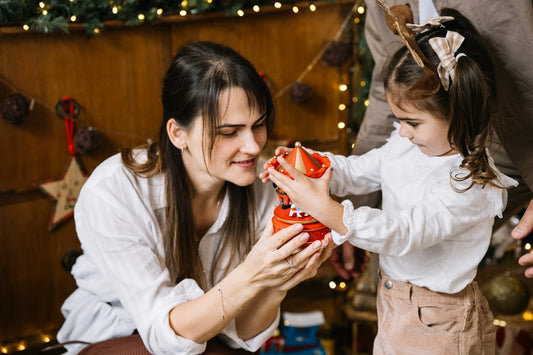 A mother holding her child close in front of a glowing Christmas tree, the warm moment behind Nordenzi's Christmas Gifts for Mom guide