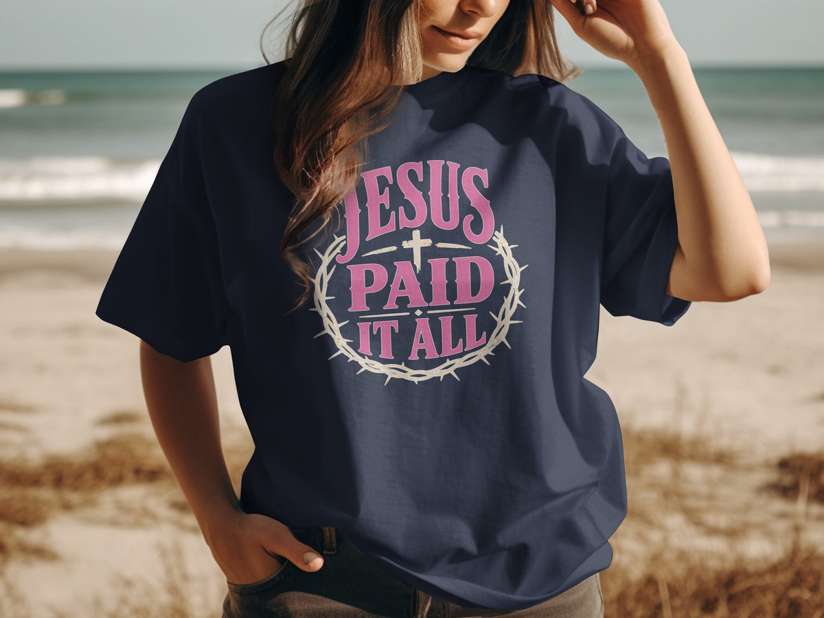 Dark blue t-shirt with pink text and cross reading "Jesus Paid It All"