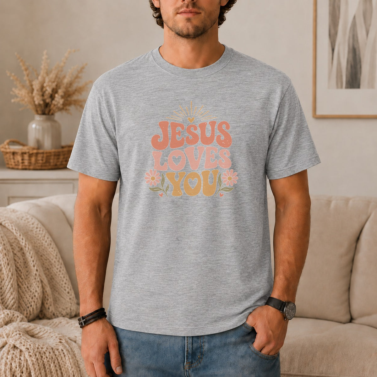 Grey t-shirt with "JESUS LOVES YOU" graphic in retro font and floral accents.