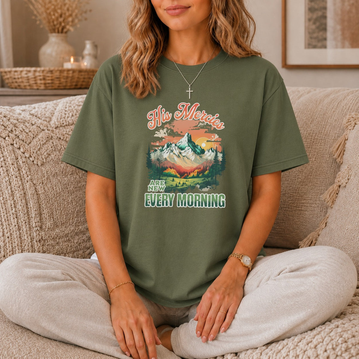 Olive green t-shirt with "His Mercies Are New Every Morning" text and mountain landscape graphic.