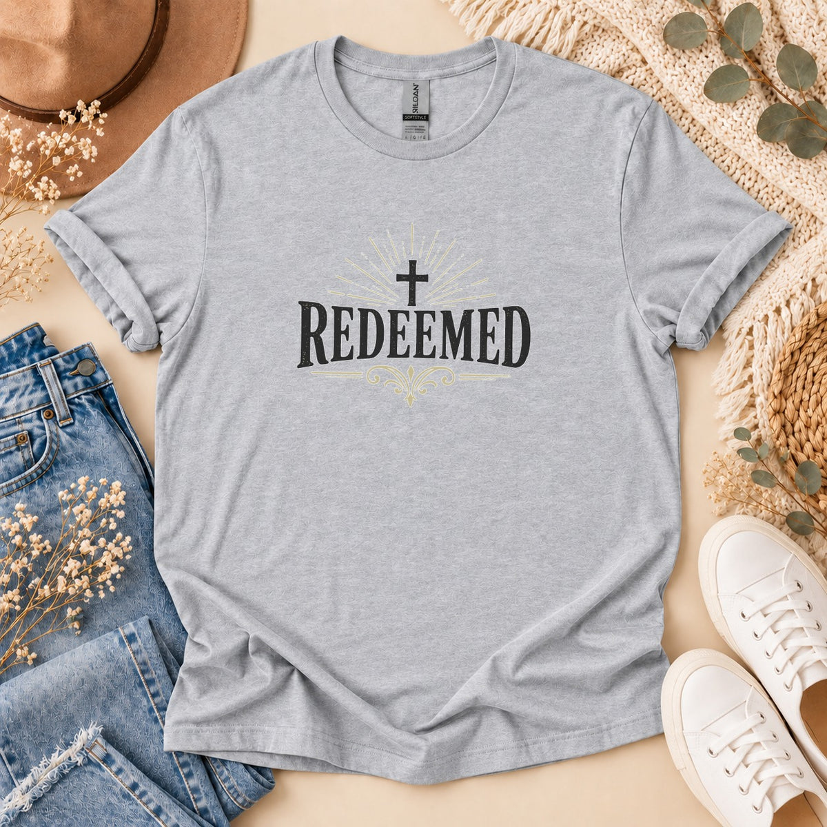 Light grey t-shirt with black text and cross reading "REDEEMED".