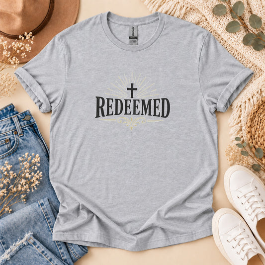 Light grey t-shirt with black text and cross reading "REDEEMED".