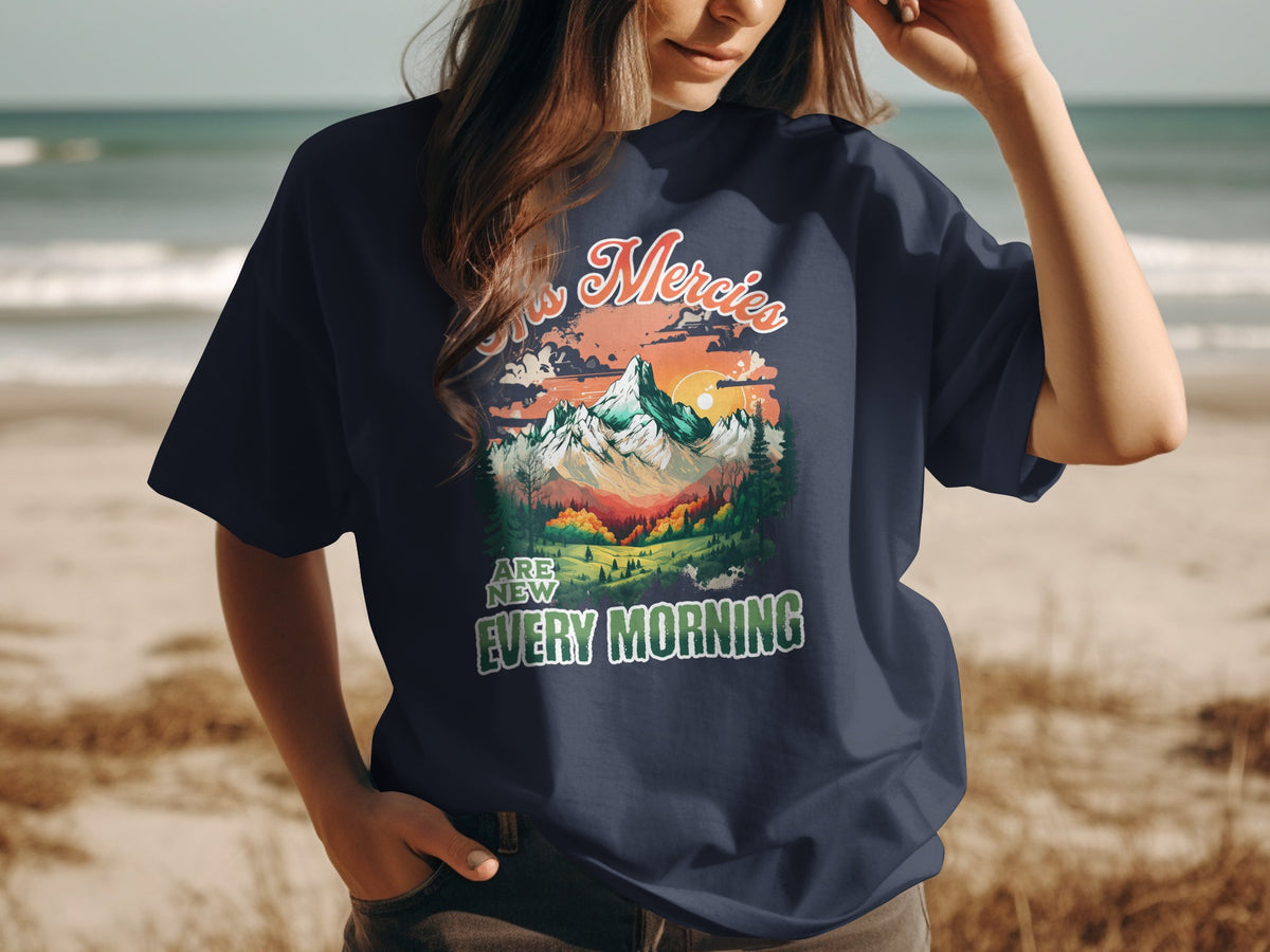 Dark blue t-shirt with "His Mercies Are New Every Morning" text and mountain landscape graphic.