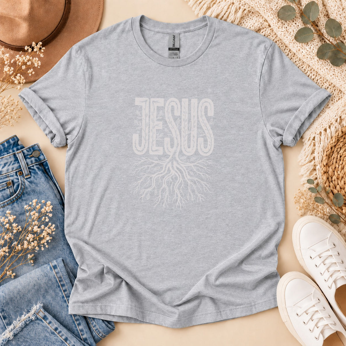 Grey t-shirt with white text "JESUS" above a root design.