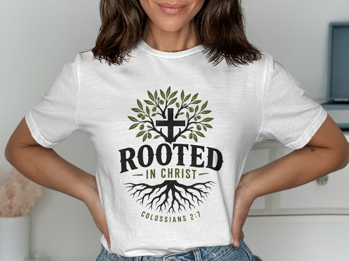 White t-shirt with graphic of a cross, olive branches, roots, and text "ROOTED IN CHRIST" and "COLOSSIANS 2:7".