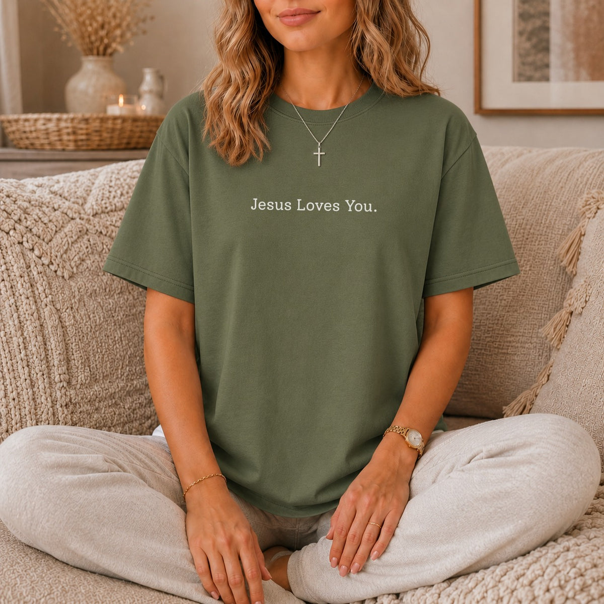 Green t-shirt with "Jesus Loves You." text and a silver cross necklace.