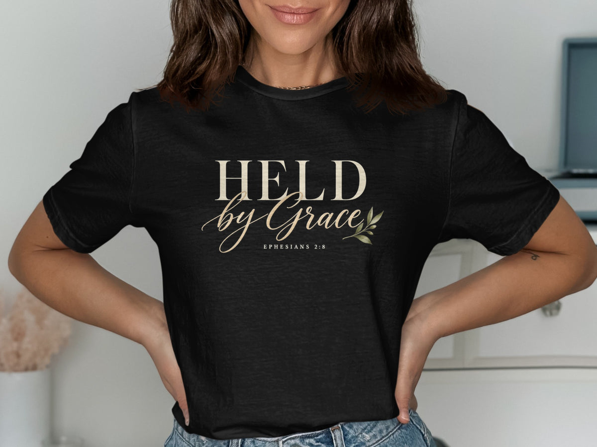 Black t-shirt with "HELD by Grace" and "Ephesians 2:8" text.
