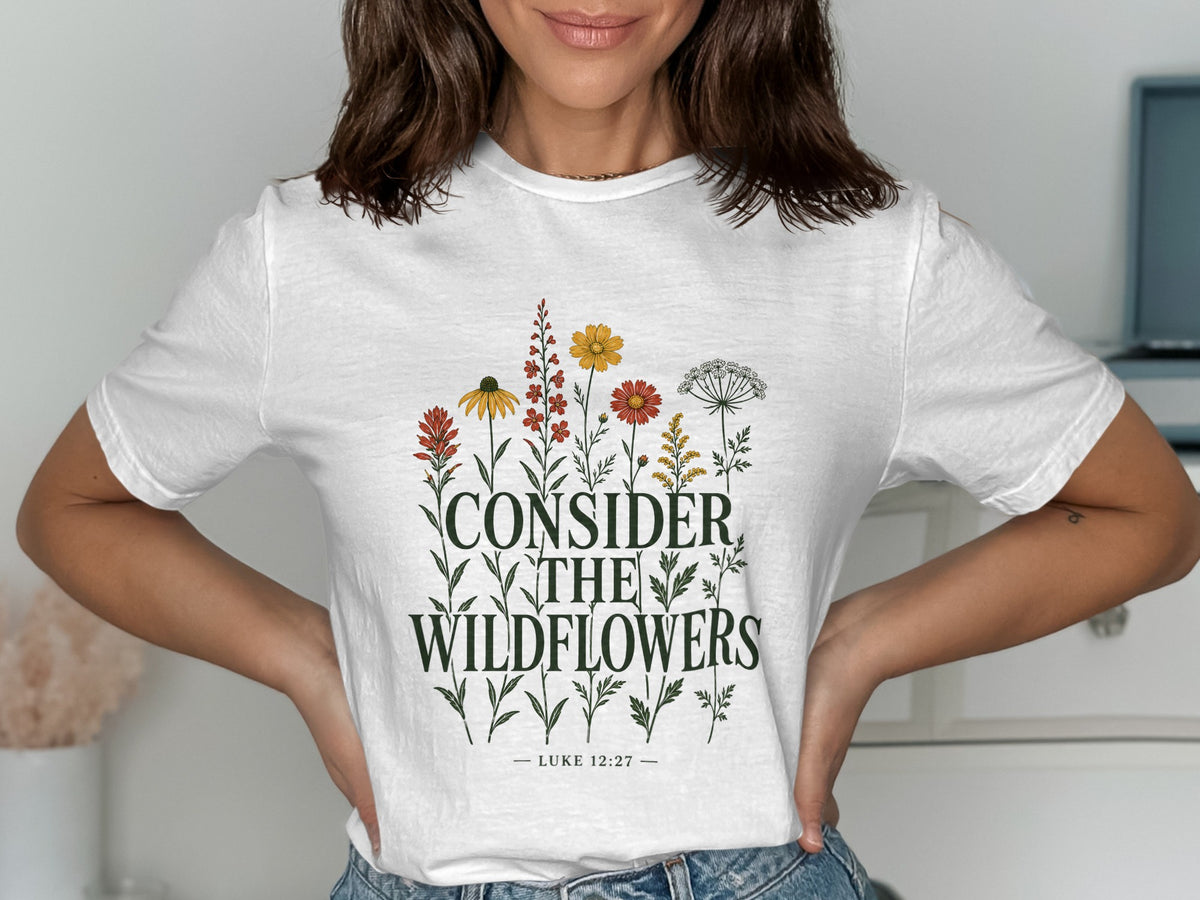 White t-shirt with "CONSIDER THE WILDFLOWERS LUKE 12:27" text and floral graphic.