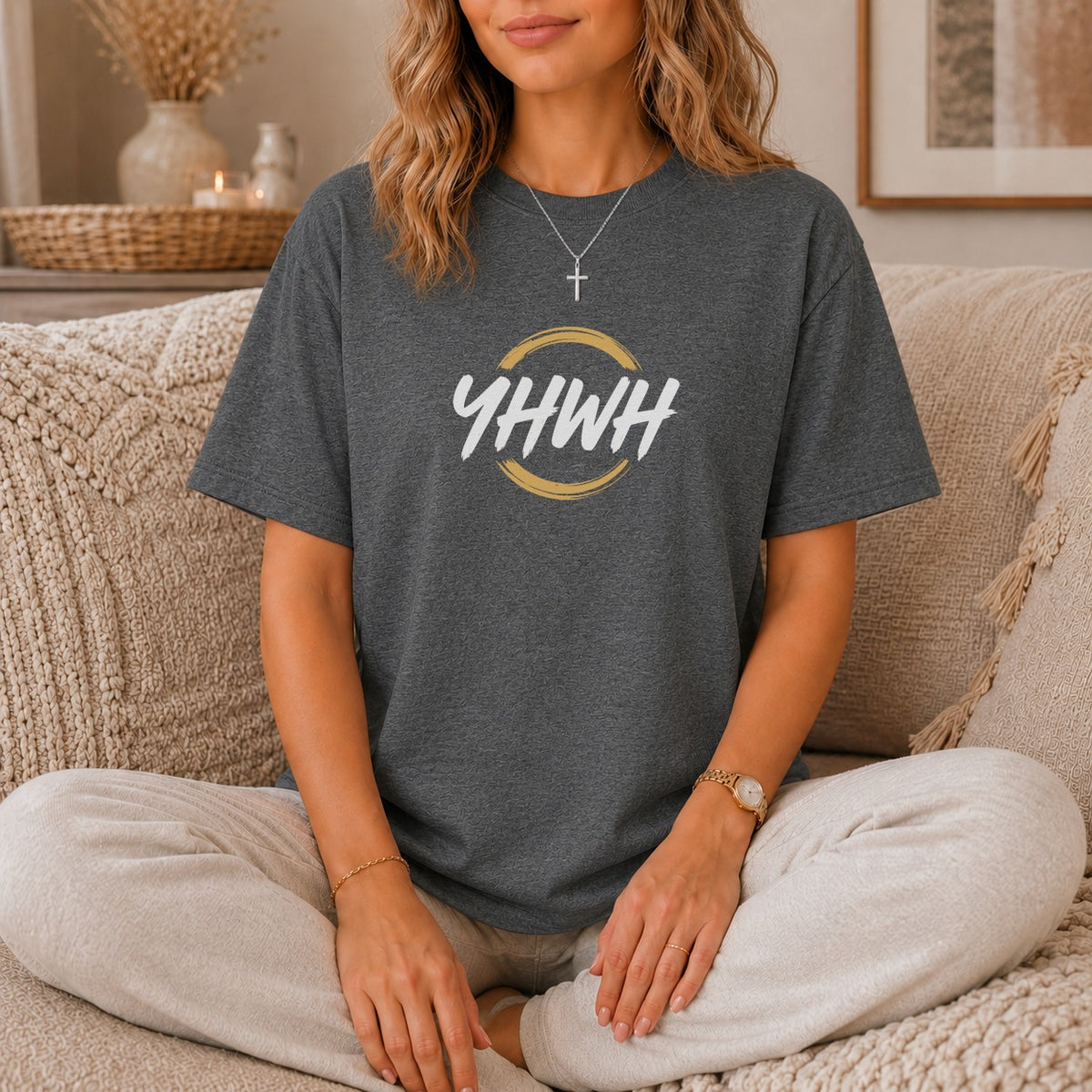 Dark grey t-shirt with white "YHWH" text inside a gold circle and cross necklace.