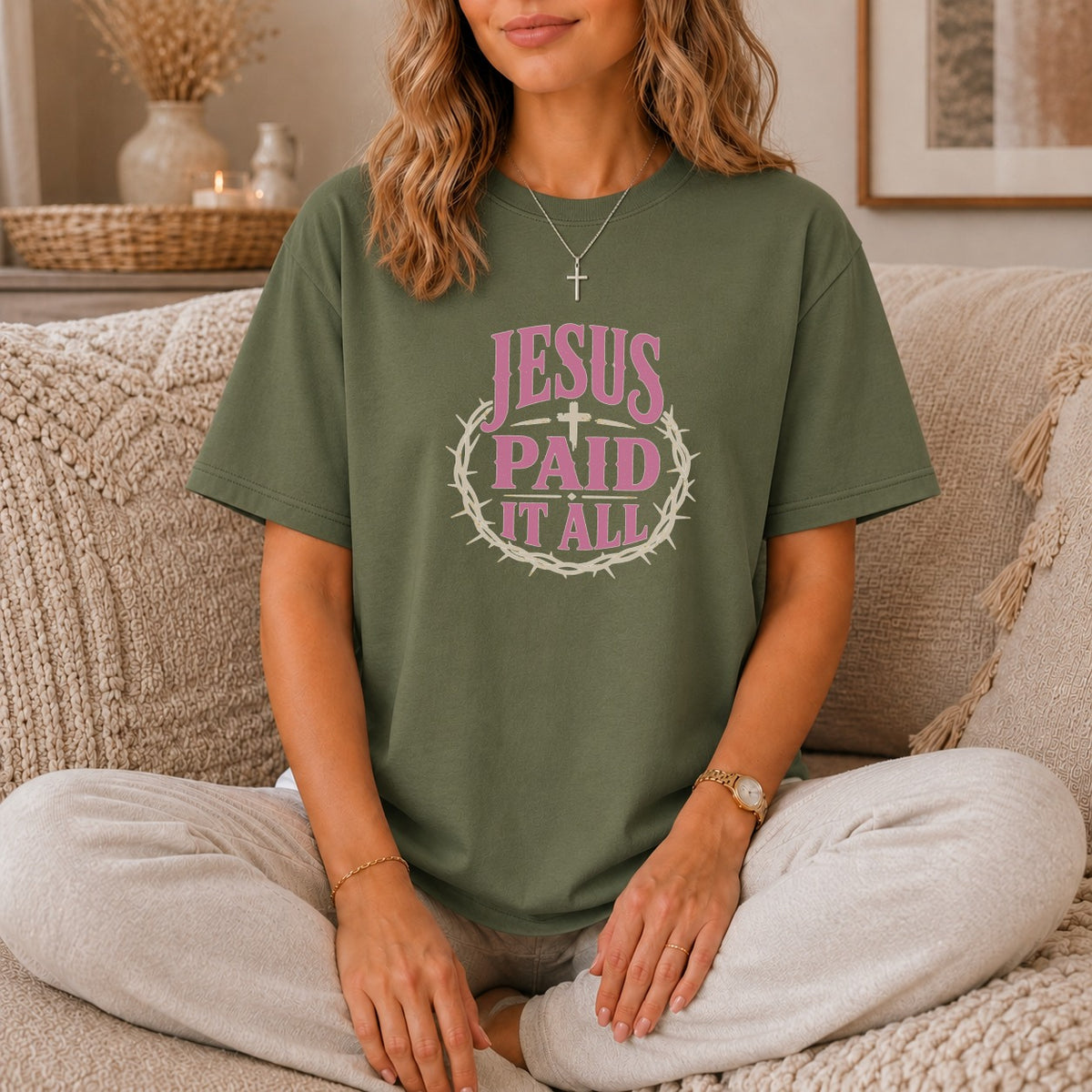 Green t-shirt with pink "JESUS PAID IT ALL" text and crown of thorns graphic.
