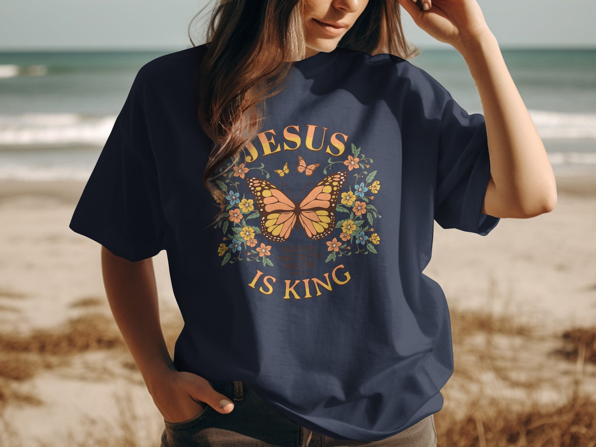 Navy t-shirt with a butterfly and floral design saying "JESUS IS KING".