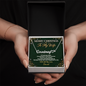 Hands holding a personalized name necklace for wife in a gift box with Christmas card