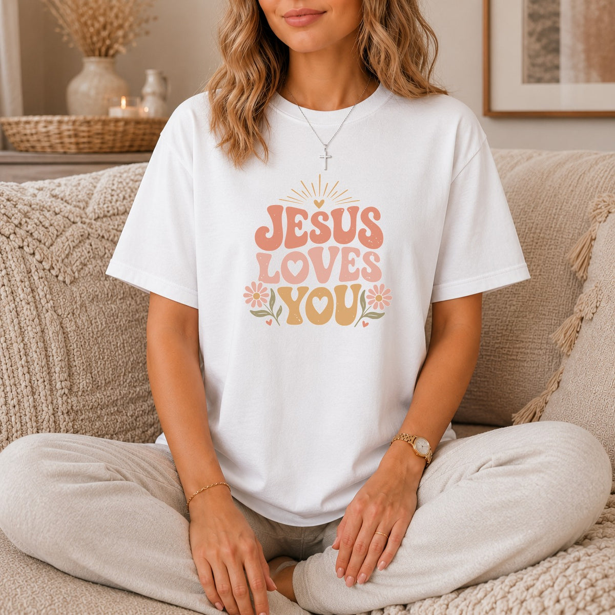 White t-shirt with "JESUS LOVES YOU" in retro font and floral accents.