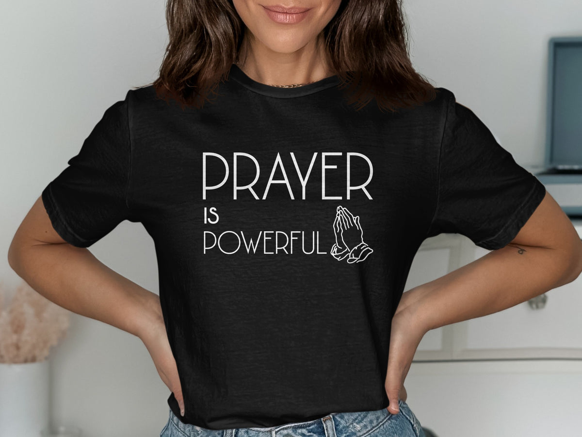 Black t-shirt with white text reading "PRAYER IS POWERFUL" and praying hands graphic.