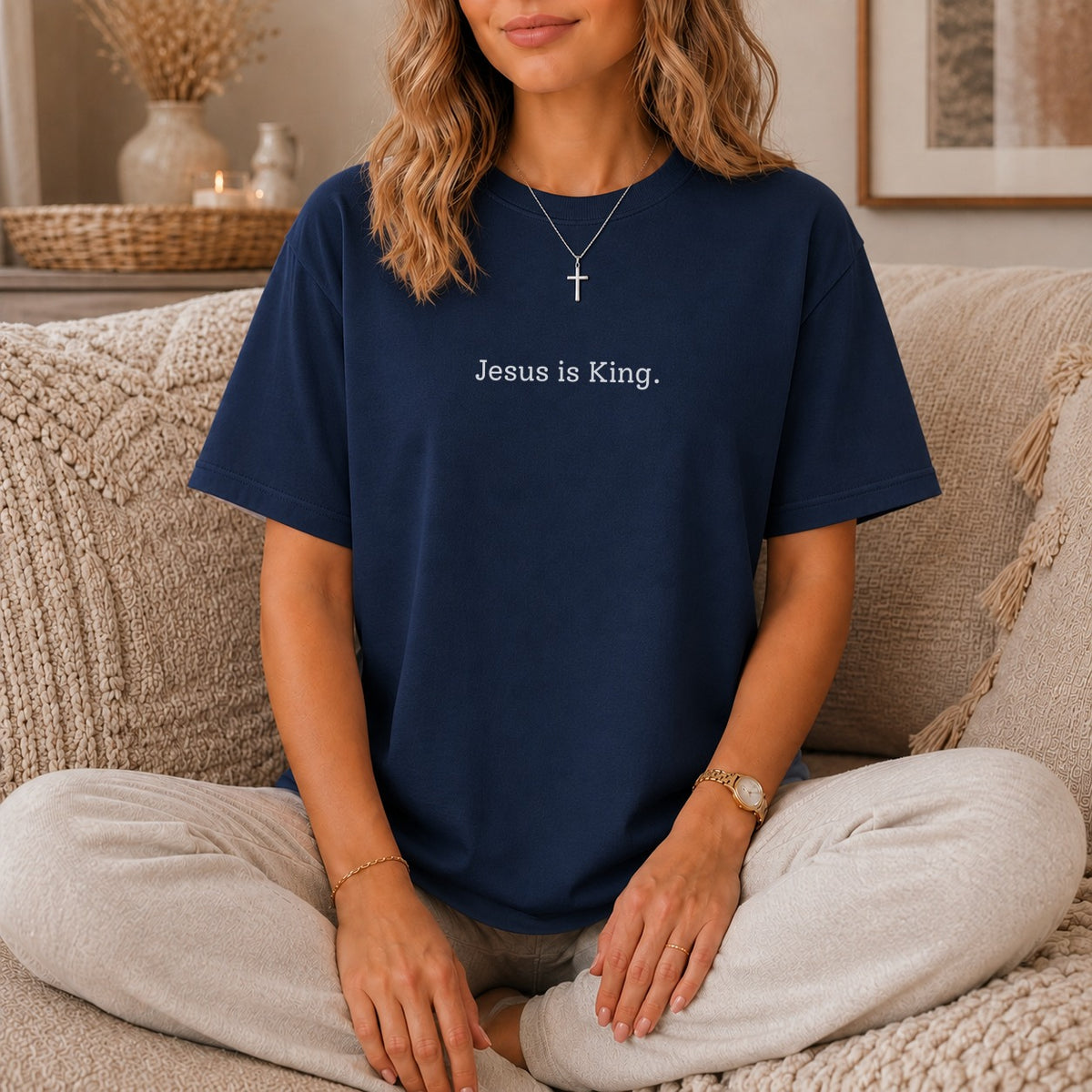 Woman wearing a navy blue t-shirt with white text "Jesus is King."