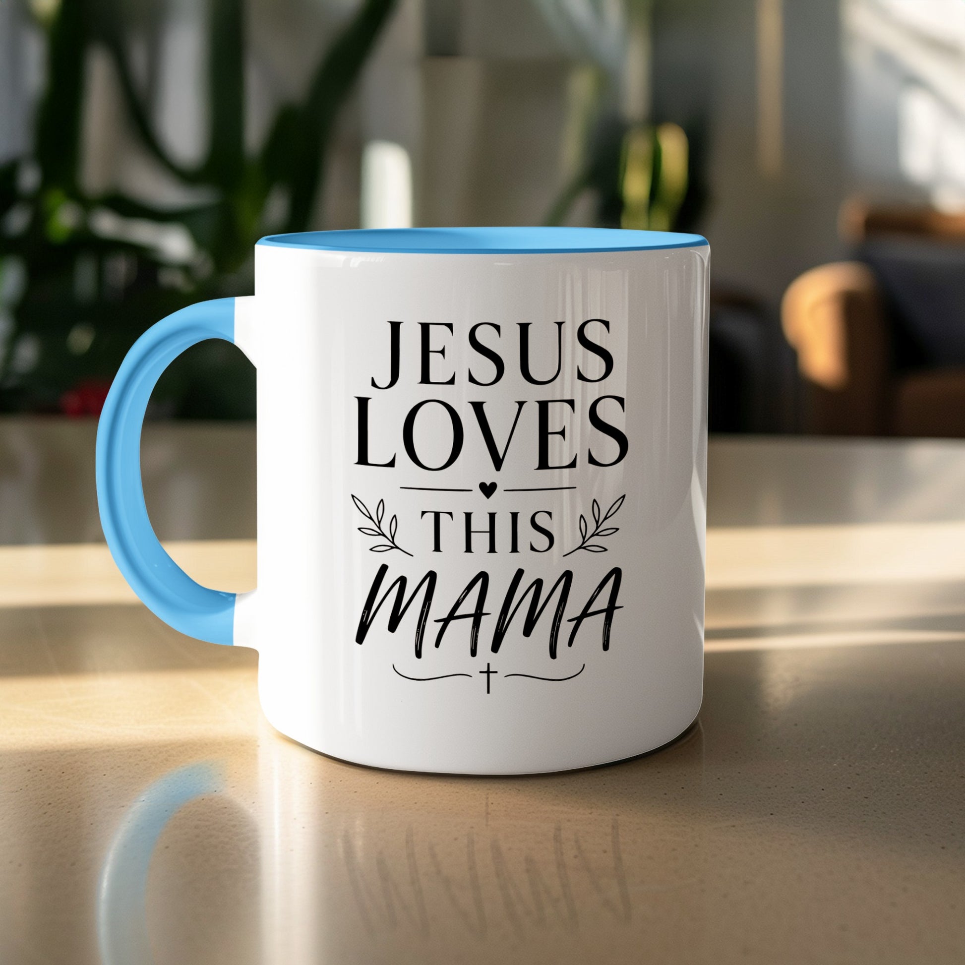 White mug with blue handle, reading "JESUS LOVES THIS MAMA" with a cross.