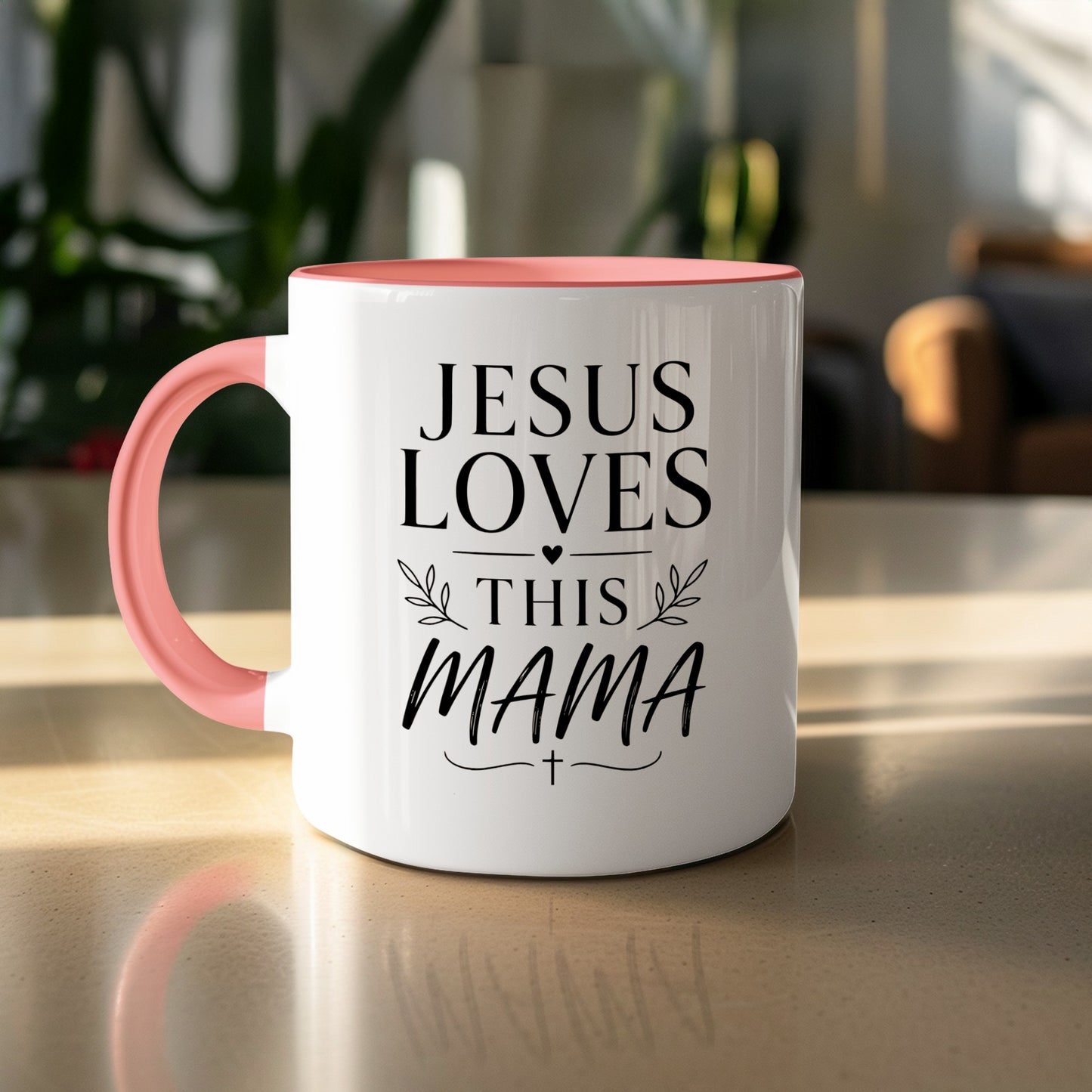 White mug with coral handle and "Jesus Loves This Mama" text.